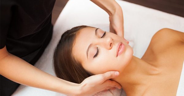 A brown-haired woman's relaxed face during a neck massage at the Treetops Resort Spa.