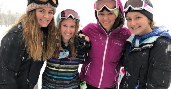 4 smiling young ladies in ski gear