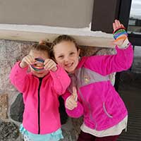 2 young girls in pink jackets smiling