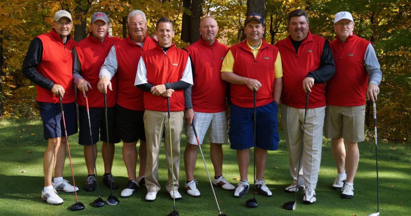A group of golfers in red uniforms enjoys a tournament at Treetops Resort