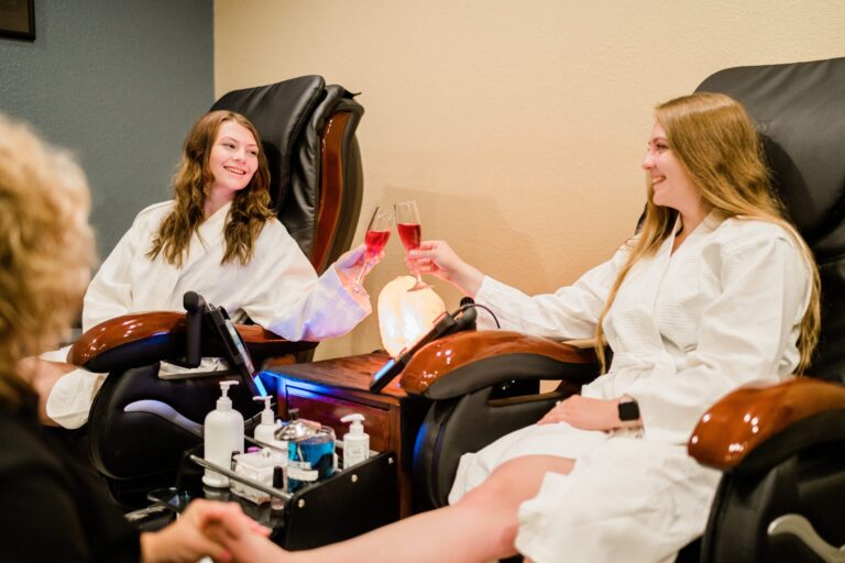 Two young women toasting a mimosa while enjoying spa pedicure|Spa Promotion Facial