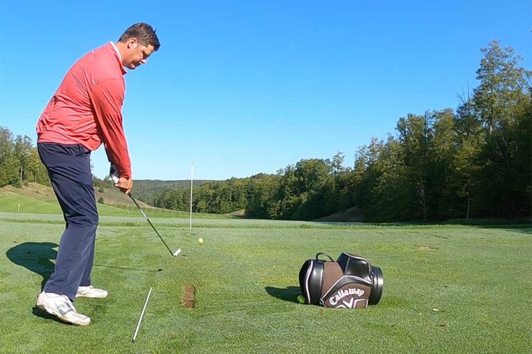 Tall man in read shirt getting ready to swing a golf club | golf practice station