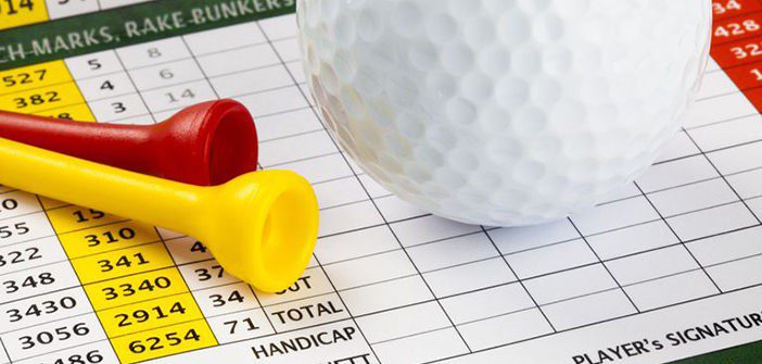 A white golf ball and yellow and red tees lay on top of a golf scorecard.