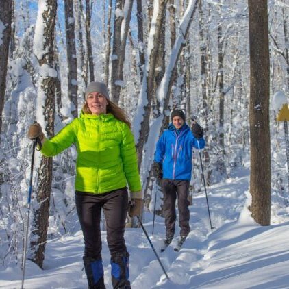 |Man and woman in ski clothes and hats on for cross country skiing michigan